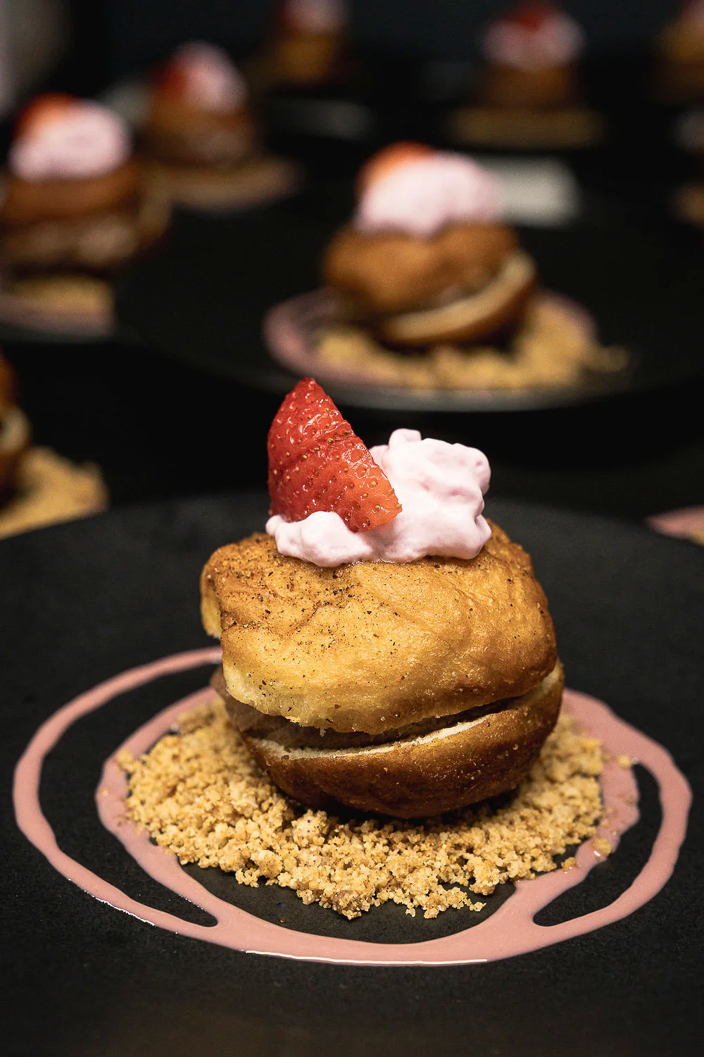 Detalle de postre de autor servido en Aroma, con fresa y crema sobre base crocante